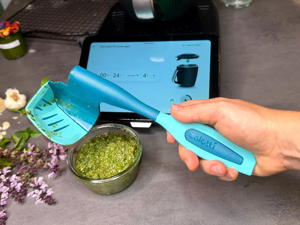 Calotti® Drehkellenspatel SILIKON+ vor dem Thermomix® TM7 Display, davor eine Schale Pesto